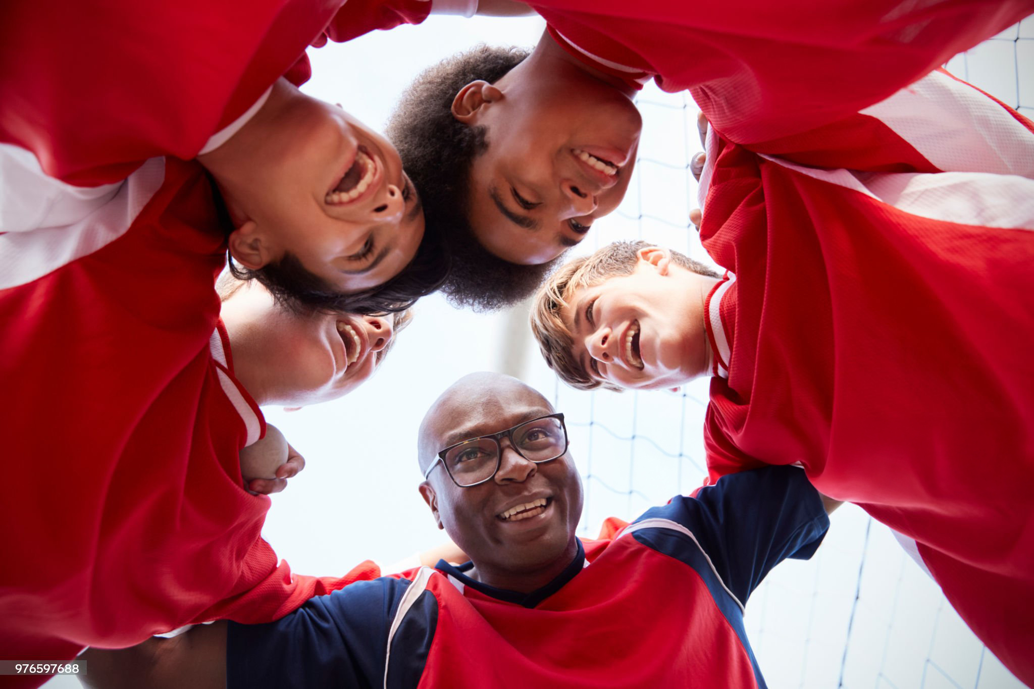 Low Angle View Of Male High School Soccer Players And Coach Having Team Talk