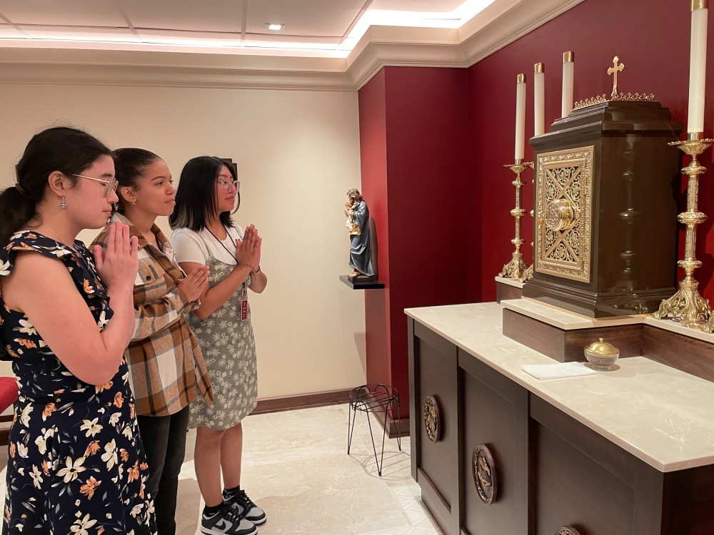 Three girls pray in chapel 1