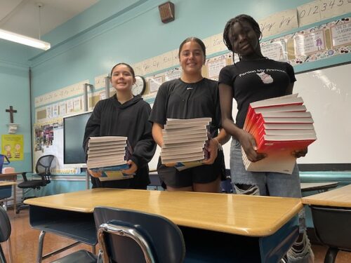 Mara Emily Rebecca with books in classroom 500x375